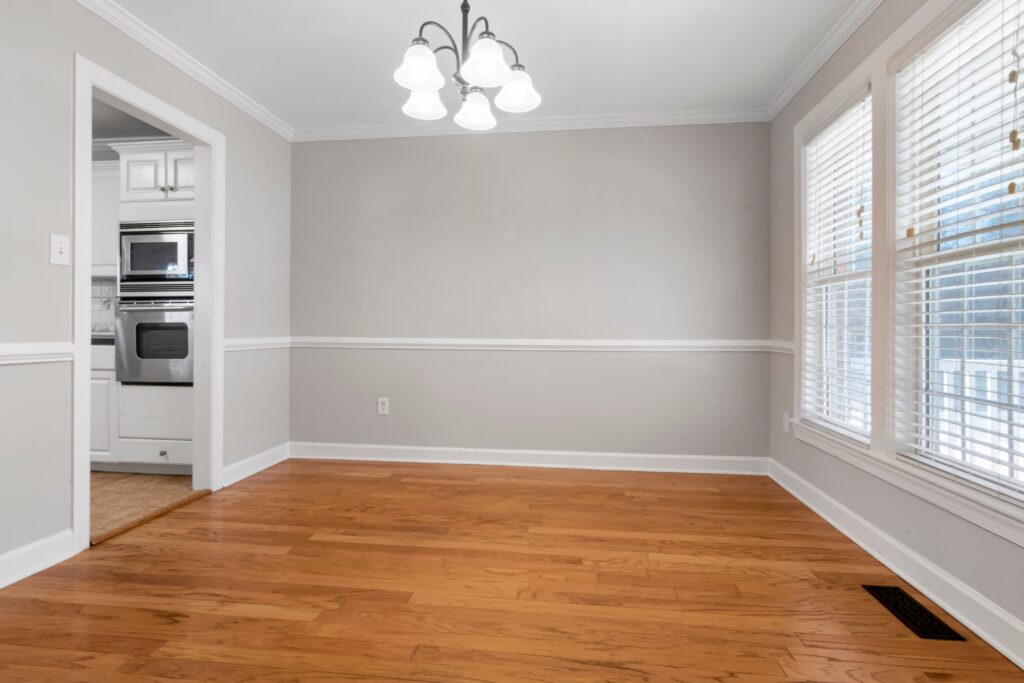 Spacious empty room with hardwood floors and white walls, ideal for interior design projects.